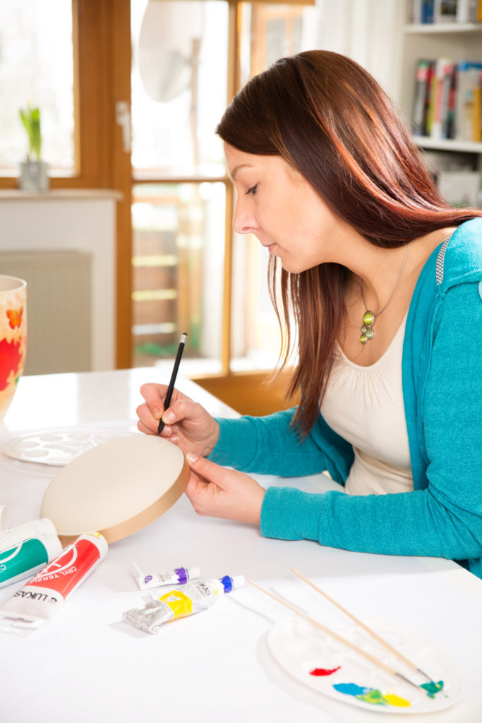 Julia bei der Bemalung einer Natururne aus biologischem Material. Es entsteht die Urne"Lovely Butterfly"