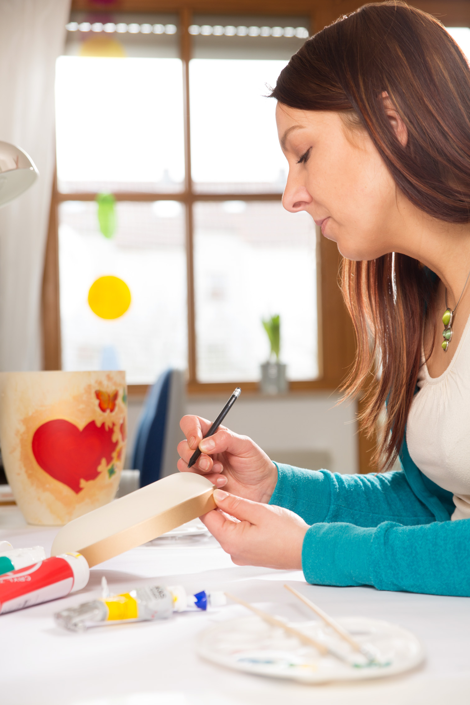 Julia in ihrem Atelier - Urnenwerk - Individuell wie das Leben Julia beim Bemalen des Deckels der "fliegenden Schmetterlingsurne"