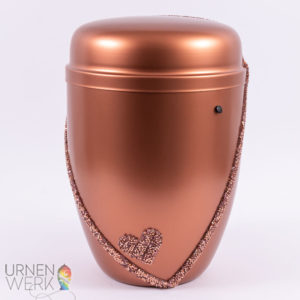 Frontansicht der kupferfarbenen Urne mit Blick auf das Detail Herz und Band